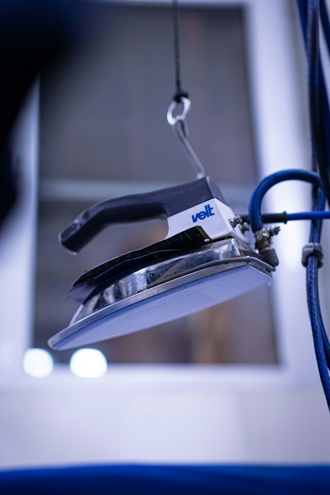 a-close-up-of-a-stapler-with-a-blue-cord-k7hx3rh2eh0